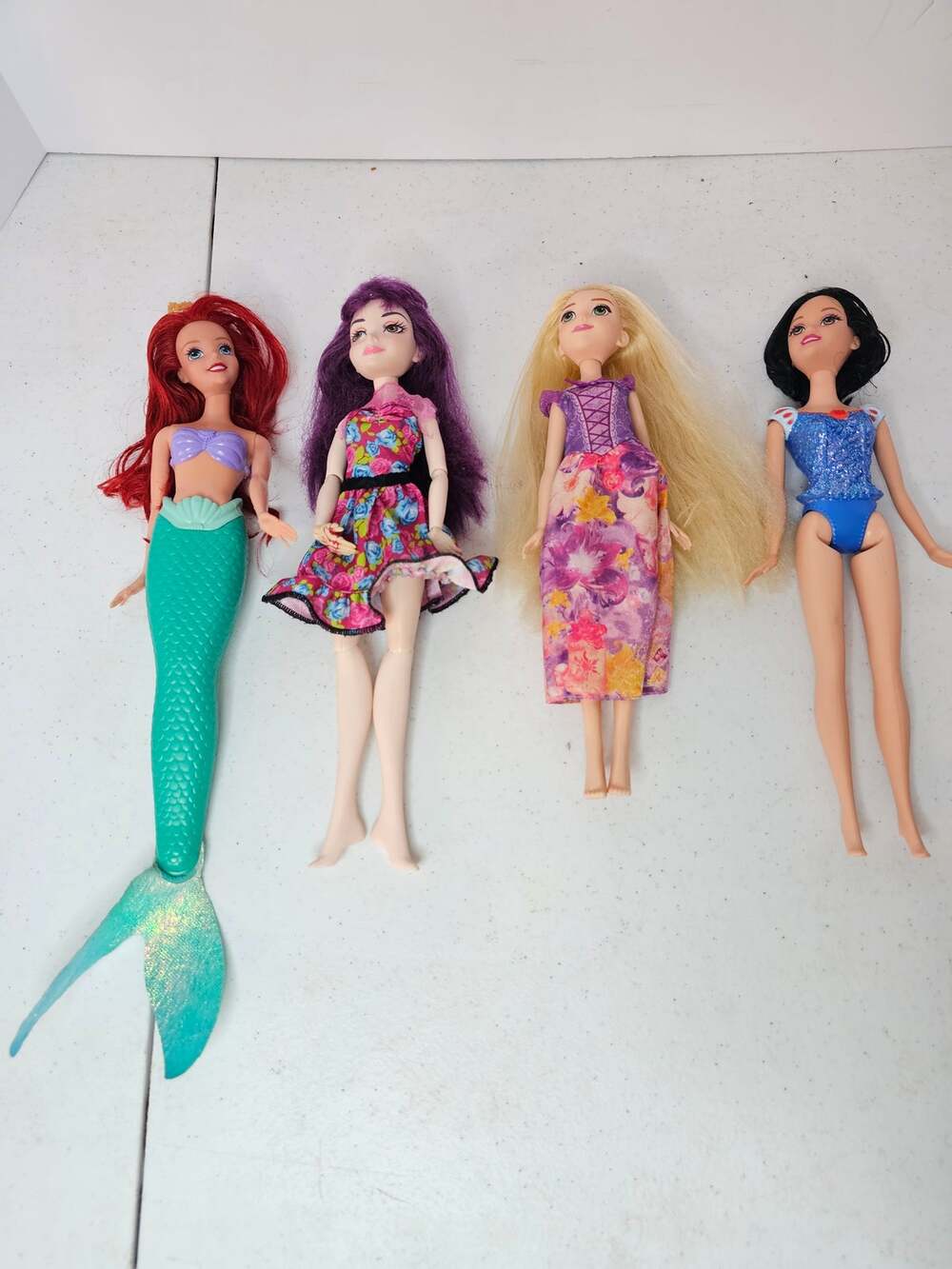 Lot of 4 Disney fashion dolls including Ariel, Rapunzel, Mal, and Snow White